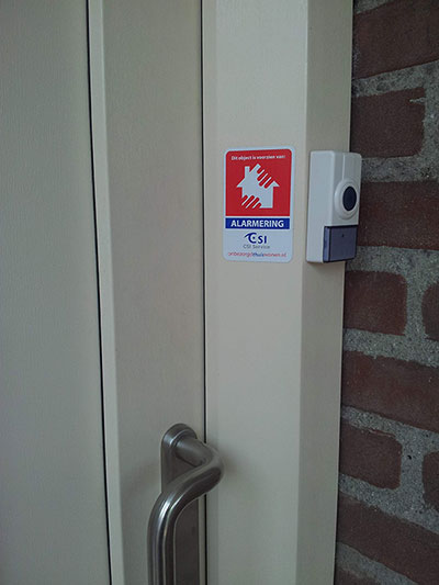 Sticker bij voordeur om te attenderen op personenalarmering